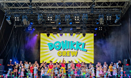 DONIKKL Crew bei einem Mitmach-Kinderkonzert auf großer Bühne mit LED-Wall